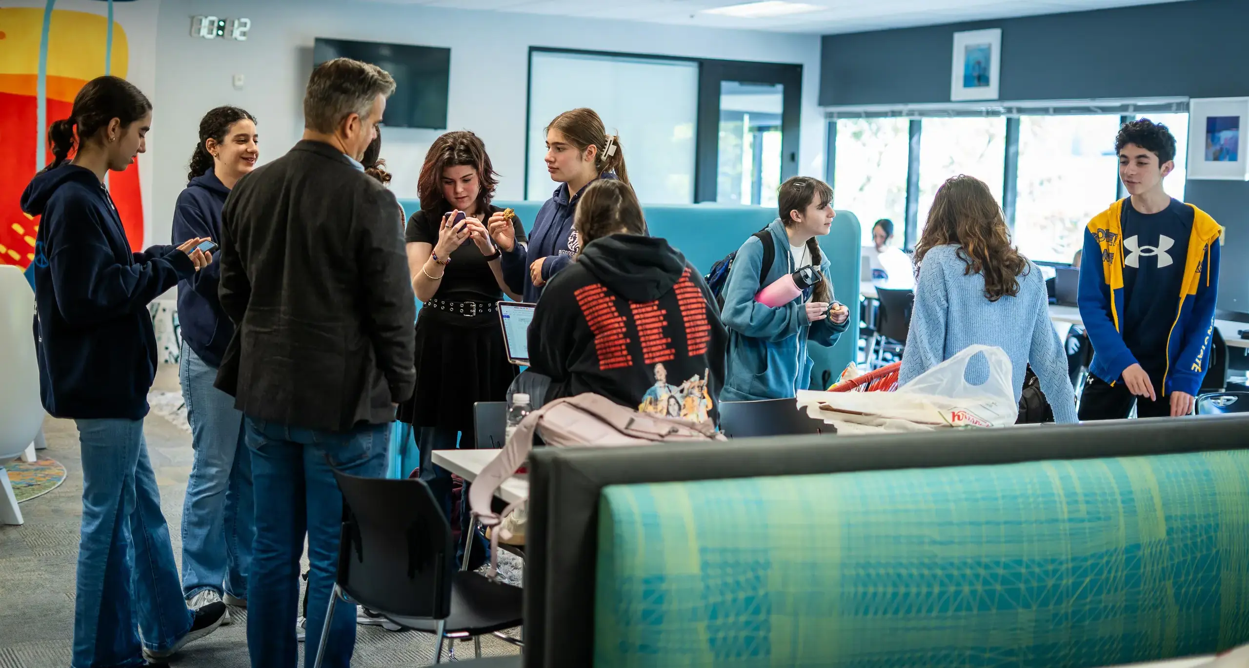 A group of diverse individuals standing together in a well-lit room,  engaged in conversation and interaction.
