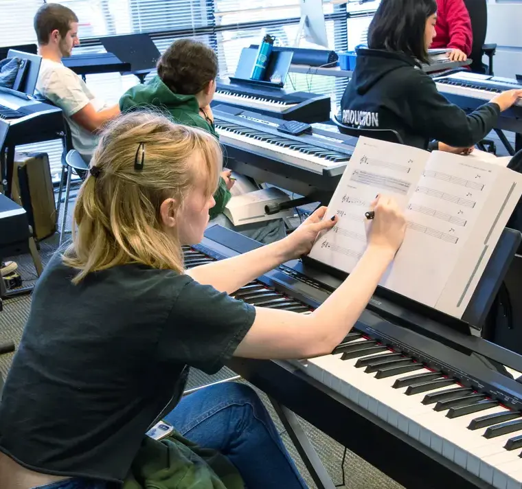 Female Student Reading Piano Music Sheet in Music Class